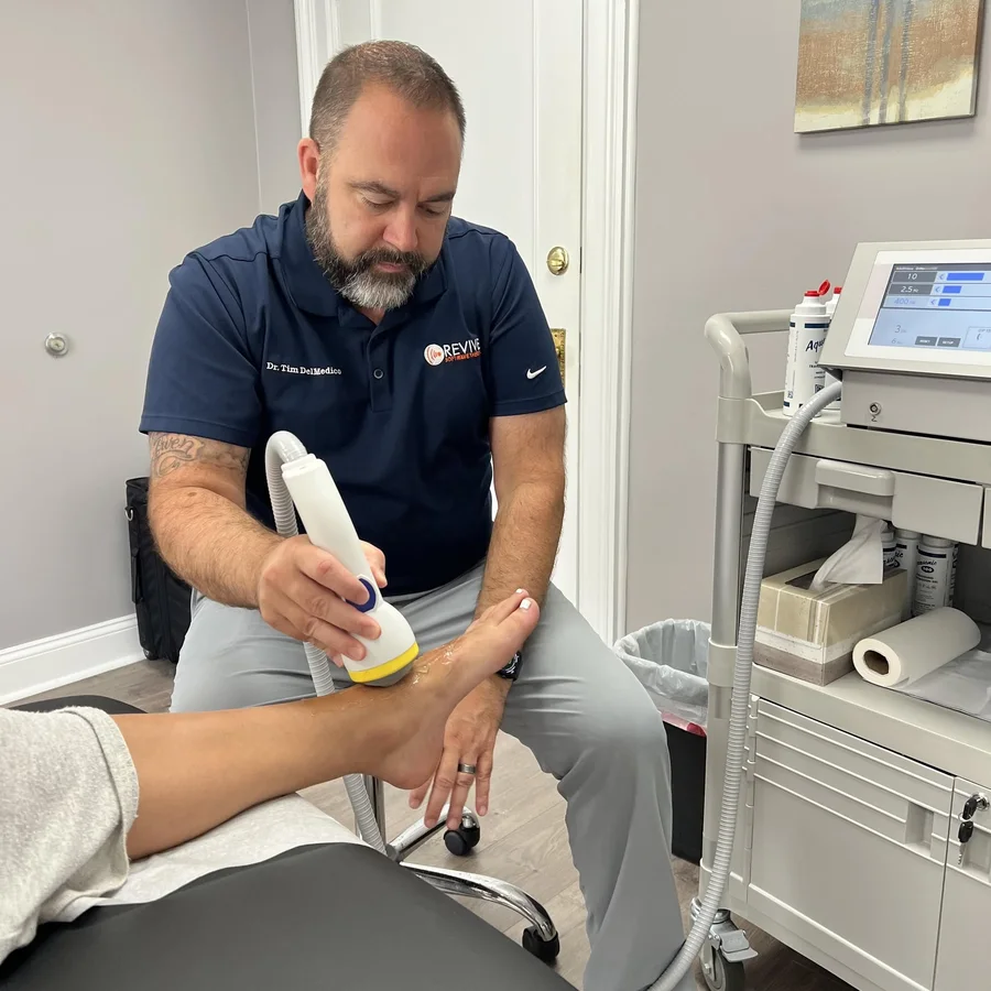 Dr. Tim DelMedico performing a SoftWave therapy treatment at Revive Health